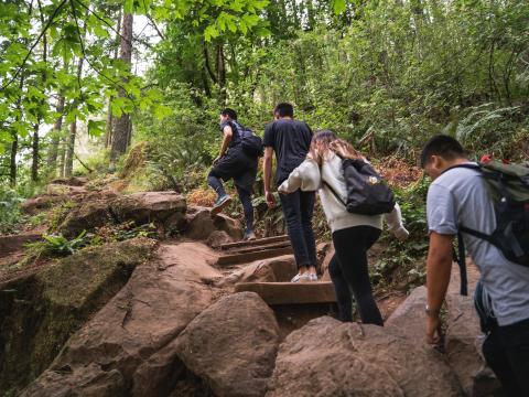 A group of students hike up a rocky trail.